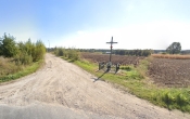 droga zwirowa wsrod pol. Obok drogi krzyz