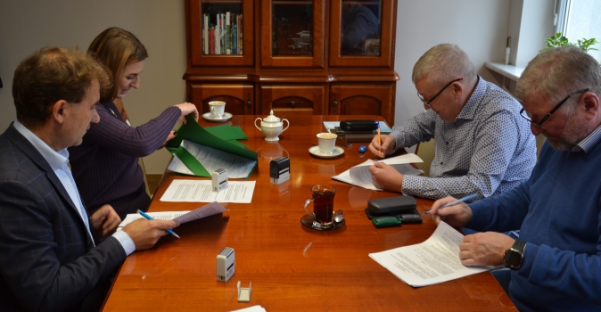 Cztery osoby podpisujace dokumenty